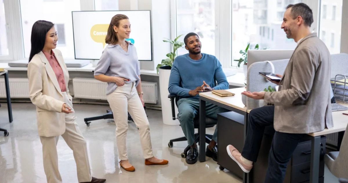 Diverse group of coworkers having a casual team discussion in a modern open-plan office